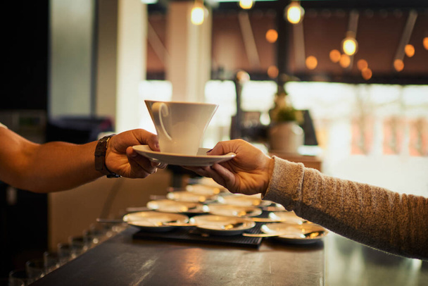 Coffee shop customer, people and barista hands with tea cup, latte or matcha for client morning hydration. Restaurant store sale, cafe server and waiter giving woman drink, diner beverage or espresso. - Foto, Bild