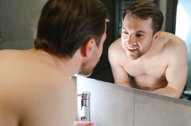 A man washes his face after shaving. - 写真・画像