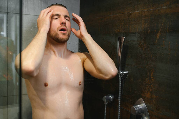 Man warming up in the shower. - Фото, изображение