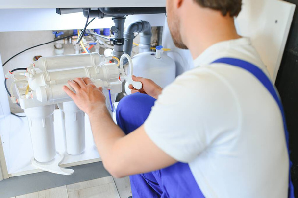 Plumber working change cartridge filter for water in kitchen. Concept filtration system - Valokuva, kuva