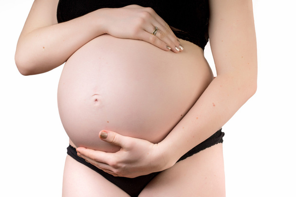 妊娠中の女性の白い側面に分離された彼女の腹を愛撫 - 写真・画像