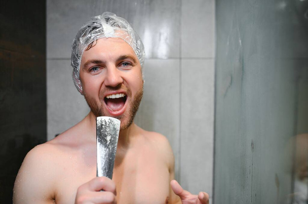 Handsome man singing while taking shower at home. - Valokuva, kuva