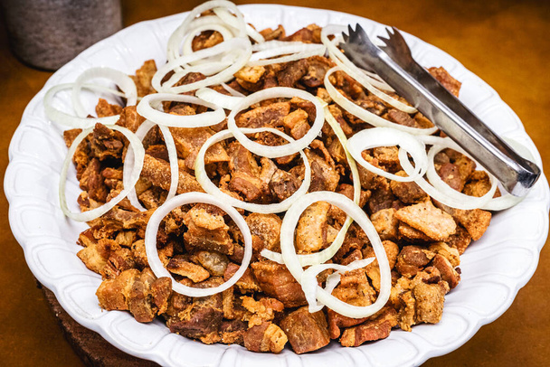 Braziliaanse varkenspest, geserveerd in buffetstijl, met uien en andere groenten, restaurantgerechten - Foto, afbeelding