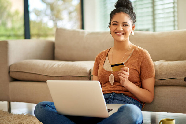 Woman, laptop and credit card with online shopping and payment on store website with fintech and smile in portrait. Female person at home, happy with internet banking and finance with e commerce. - 写真・画像