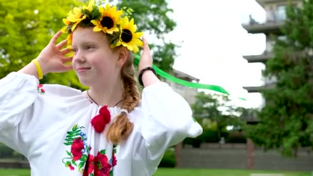 mooie jonge tiener meisje in krans voor Oekraïense vakantie met vriend communiceren plaats voor reclame tekst Oekraïense traditie zet een krans op haar hoofd weven vlechten geborduurde shirts - Video