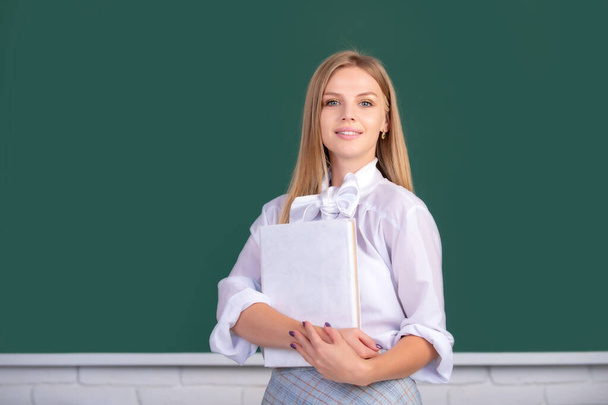 Portrait of a young, confident and attractive cute blonde female student studying in school classroom - Foto, imagen