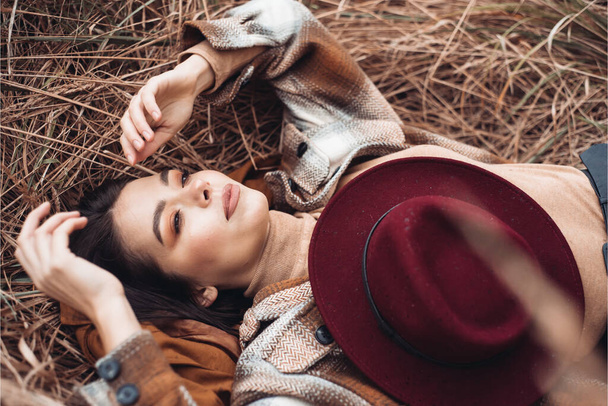 portrait of stylish woman in a hat lying on the ground  - Fotoğraf, Görsel