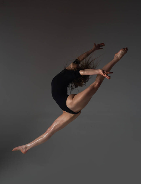 Leg-split jump. Flexible woman. Fit girl stretching and dancing. Stretching sexy flexible body. Flexible woman gymnast. Inspiration. Graceful ballet dancer. Art, motion, flexibility concept - Foto, Imagem