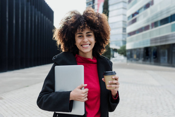 young African American business woman holding laptop or computer in city of Latin America, Hispanic financial and caribbean people  - Foto, afbeelding