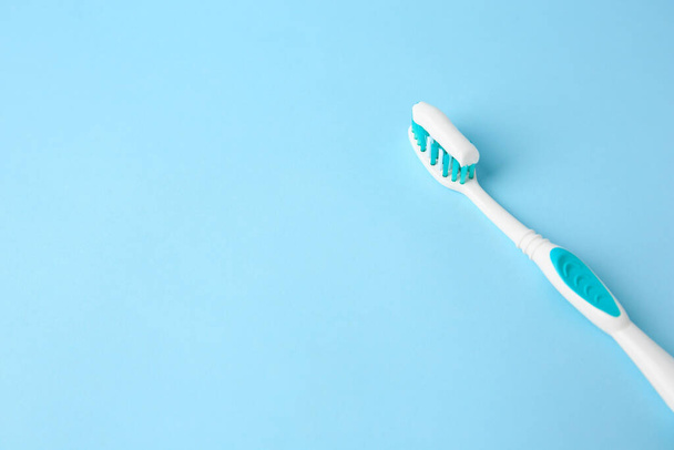 Brush with toothpaste on light blue background, space for text - Photo, Image