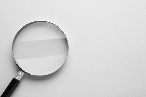 Magnifying glass on light grey background, top view. Space for text - Foto, Imagem