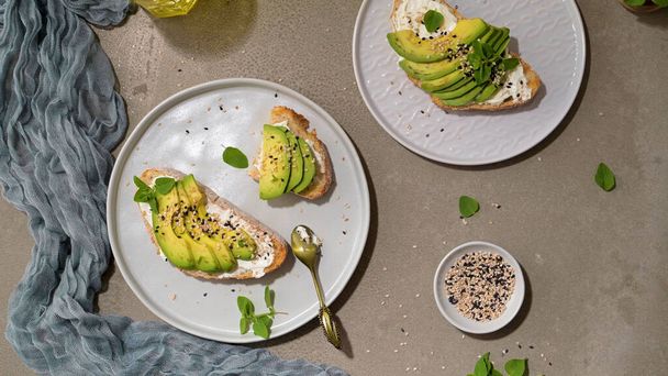 Healthy toast with avocado cream cheese and wheat bread on a plate. Delicious snacks and avocado sandwiches. Food composition, tasty Italian meal. - Foto, imagen