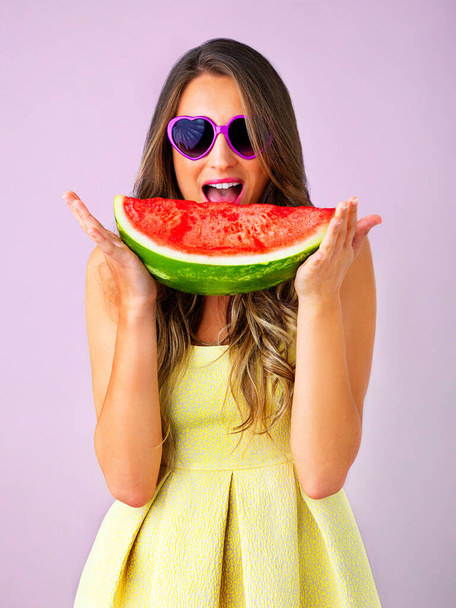 Fresh and delicious. Studio shot of a beautiful woman holding a watermelon against a pink background - Foto, afbeelding
