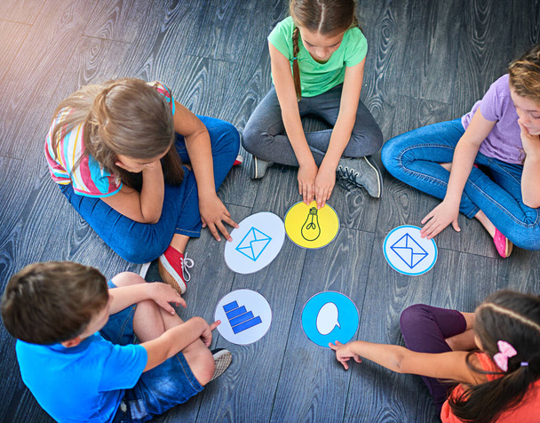 Leiki yhdessä, opi yhdessä. Korkea kulma laukaus ryhmä lapsia pelaa peliä yhdessä lattialla - Valokuva, kuva