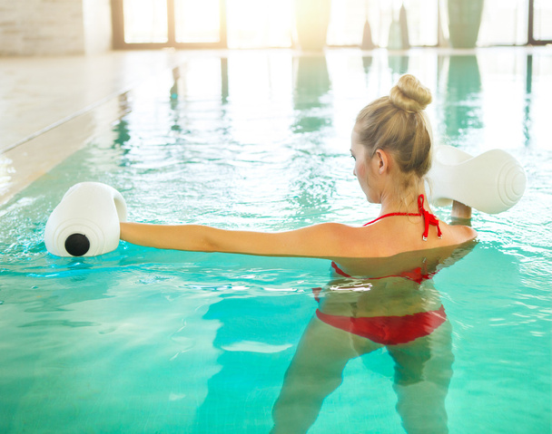 Blond young woman doing aqua aerobics - Foto, afbeelding