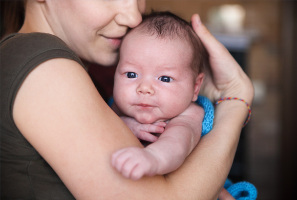 Babyjongen in de armen van haar moeder - Foto, afbeelding