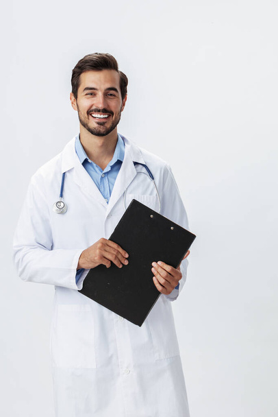 Άνθρωπος γιατρός σε λευκό παλτό με στηθοσκόπιο και φάκελο για σημειώσεις και αρχεία ασθενών χαμόγελο και καλά αποτελέσματα των δοκιμών σε λευκό απομονωμένο φόντο, αντίγραφο χώρου, χώρος για κείμενο, την υγεία. Υψηλής ποιότητας φωτογραφία - Φωτογραφία, εικόνα