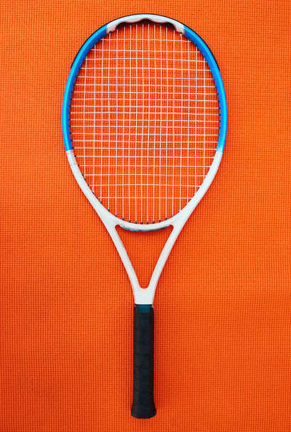 その種の最高のもの。スタジオ内のオレンジの背景に置かれたテニスラケットの高い角度のショット - 写真・画像