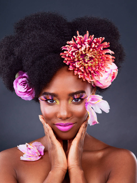 Makeup, flowers and art with portrait of black woman in studio for beauty, creative or spring. Natural, cosmetics and floral with model isolated on gray background for color, self love or confidence. - Photo, image