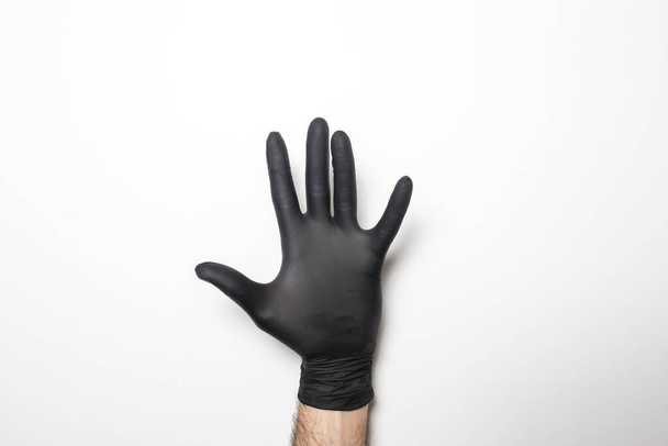 Medical black gloves on a male hand on a white background. - Photo, Image