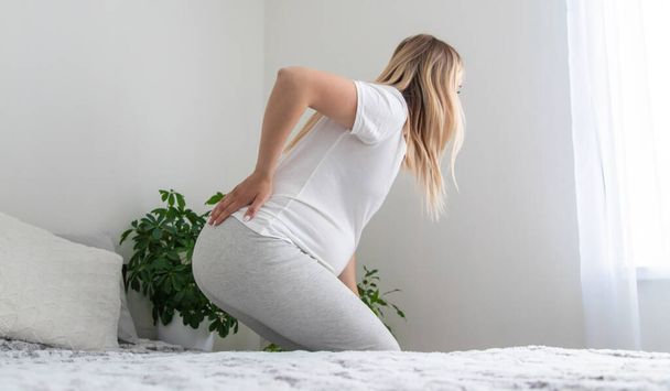 Pregnant woman hurts her back. Selective focus. Home. - Foto, imagen