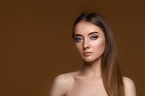 portrait of beautiful young woman with perfect skin on beige background. copy space - Zdjęcie, obraz