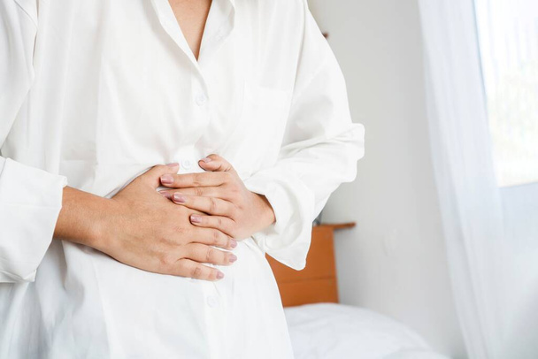 femme ayant avec le système digestif main tenant douleur à l'estomac - Photo, image