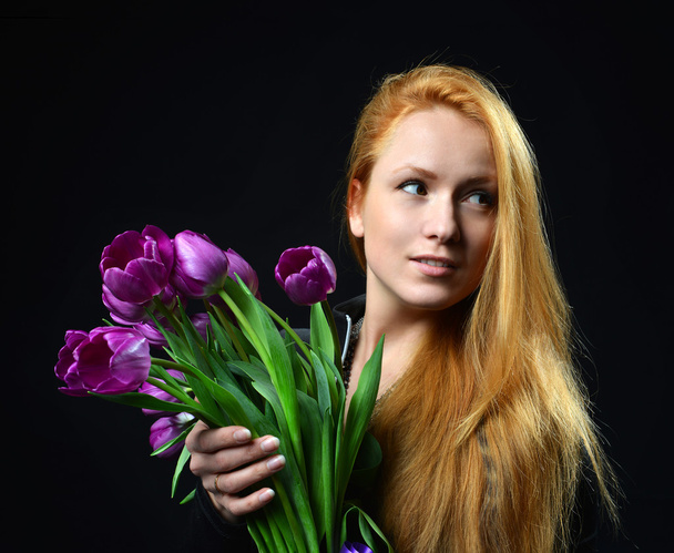 Beautiful redheaded girl hold bouquet of purple tulips flowers  - Fotoğraf, Görsel