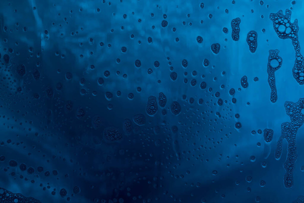 Blue texture with natural soap foam pattern on glass - Фото, зображення