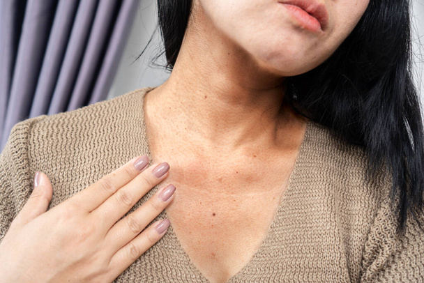 closeup woman having a problem with neck wrinkles, dark skin, aging process concept; - Fotografie, Obrázek