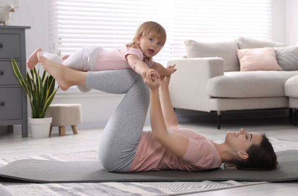 Mother doing exercise with her daughter at home - Fotoğraf, Görsel