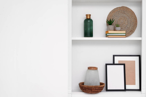 Shelves with different decor near beige wall, space for text. Interior design - Φωτογραφία, εικόνα