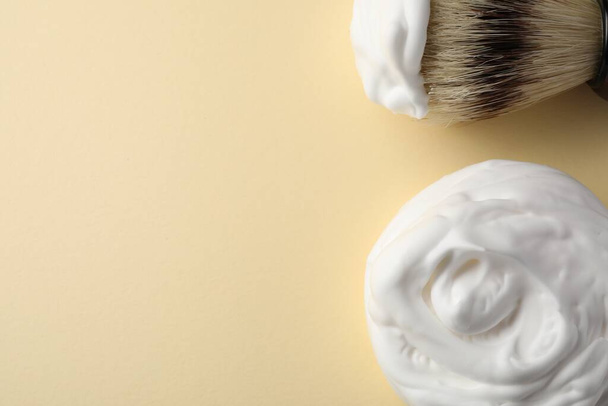 Brush and shaving foam on beige background, flat lay. Space for text - Fotoğraf, Görsel