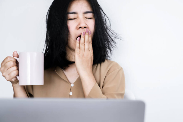 trabalhada demais Asiática empresária bocejando na mesa de escritório mão segurando uma xícara de café sentindo cansado e sonolento - Foto, Imagem