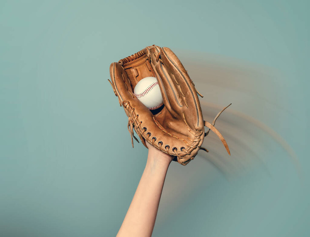 Een honkbalhandschoen op zijn hand vangt witte bal - Foto, afbeelding