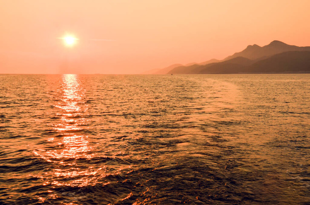 Beautiful sunset behind the Mljet island in Croatia, Europe. Mljet island from a sailboat. - Photo, Image
