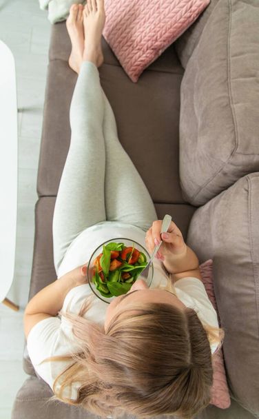 Těhotná žena jí salát se zeleninou. Selektivní soustředění. Jídlo. - Fotografie, Obrázek