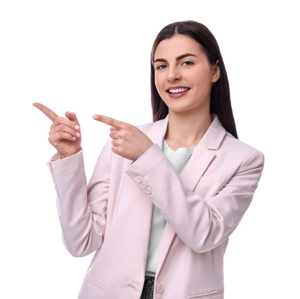 Beautiful businesswoman in suit pointing at something on white background - Foto, afbeelding