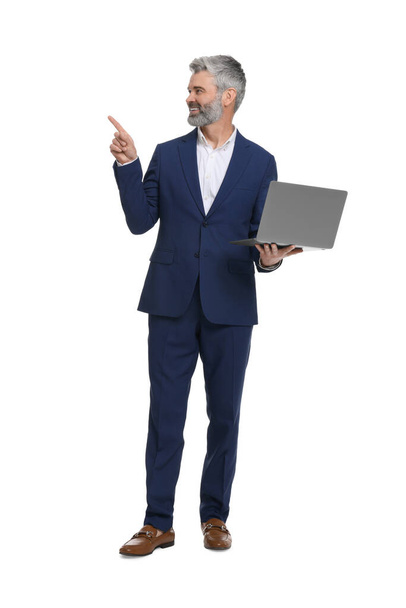 Mature businessman in stylish clothes with laptop on white background - Fotó, kép