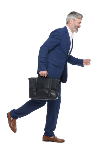 Mature businessman with briefcase walking on white background - Fotoğraf, Görsel