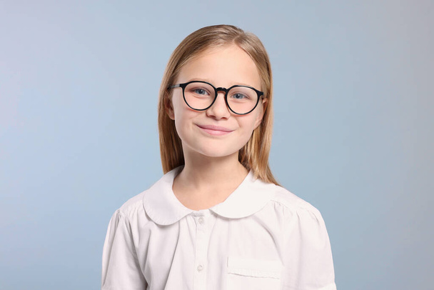 Portrait of cute girl in glasses on light grey background - 写真・画像