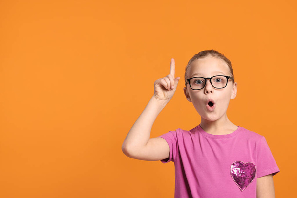 Portrait of cute girl in glasses on orange background. Space for text - Fotografie, Obrázek