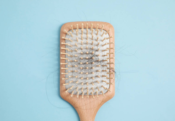 Wooden brush with lost hair on light blue background, top view - Фото, зображення