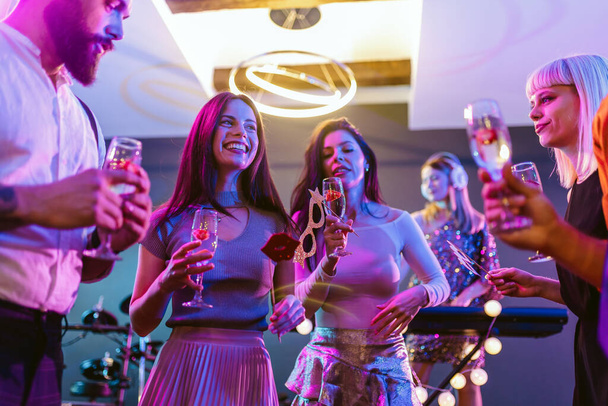 Skupina lidí tančí v klubu s DJ v pozadí - Fotografie, Obrázek