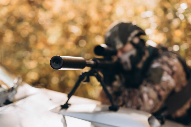 Amerikaanse soldaat in bestrijding munitie met wapen in de handen van uitgeruste laser bezienswaardigheden is in de slag bij bestelling. Mixed media - Foto, afbeelding