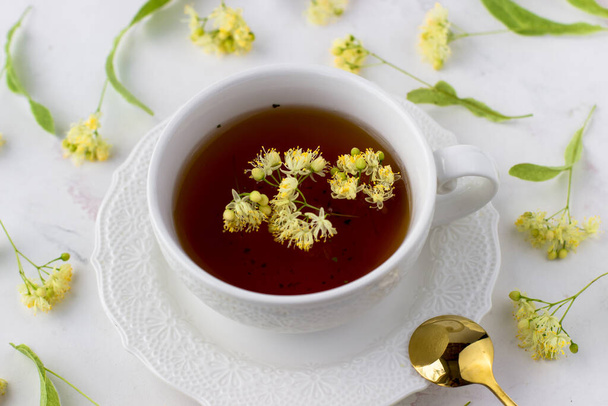 Guérison thé au citron vert dans une tasse blanche sur un fond blanc. Thé sain - Photo, image