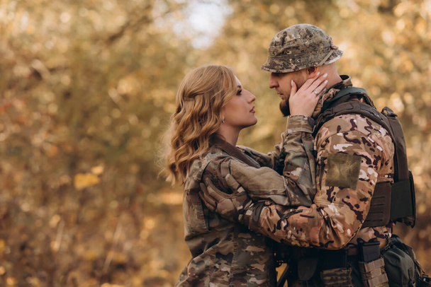 Een jonge, gelukkige soldaat van het Amerikaanse leger en zijn vrouw zijn blij elkaar te ontmoeten.. - Foto, afbeelding