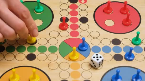 People play Ludo or Pachisi board game on beautiful wooden play board. Ludo is a strategy board game for two to four players. 4K resolution family board game video - Video