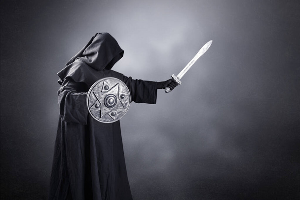 Dark knight with sword and shield over dark misty background - Photo, image