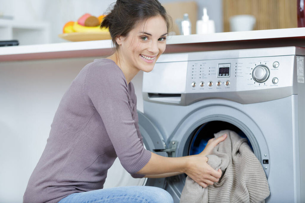 happy woman using washing machine at home - Foto, afbeelding